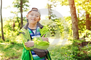 Cute happy boy having fun in forest. Family camping time. Summer vacation, family time on nature