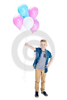 cute happy boy holding balloons and smiling at camera