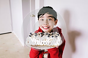 Cute happy boy holding homemade blueberry pie