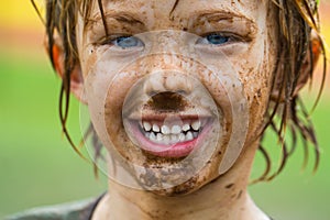 Cute, happy child with dirty face after playing