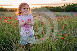 Cute happy child girl in poppy field. Happy childhood concept