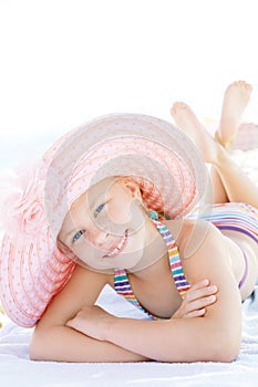 Cute happy child lying down on deckchair of beach resort