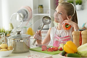 Cute happy girl coocking on kitchen and listening to music