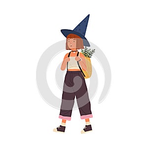 Cute happy girl wearing witch hat carry backpack full of magical herbs. Funny portrait of joyful little wizard with