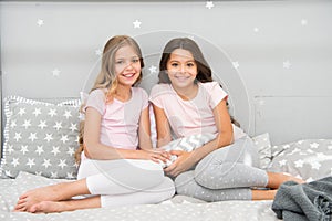 Always cute. Happy girls sit on bed. Beauty look of little girls. Small girls wear home clothing. International day of