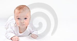 Cute happy healthy caucasian baby lying on stomack on a white blanket  looking at camera.Banner  copy space for text