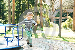 Cute happy kid. Boy playing on playground in a park.