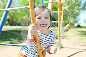 Cute happy little boy with lolly in summer