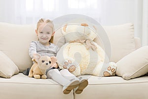 Cute happy little casual girl embracing teddy bear.