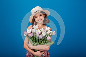 Cute happy little girl with bouquet of flowers