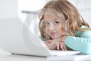 Cute and happy little girl children using laptop computer