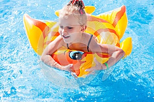 Cute happy little girl having fun in swimming pool