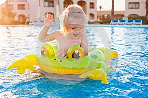 Cute happy little girl having fun in swimming pool
