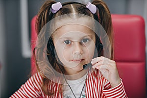 Little cute child girl wearing headphones. Preschool girl or kid listening to music isolated on gray background. Melody