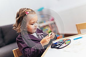 Happy little girl, preschooler, painting with water color, selective focus