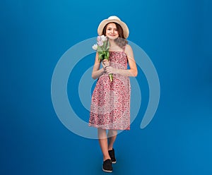 Cute happy little girl standing and holding fresh tulips