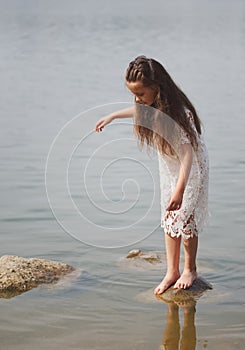 Cute happy little girl in sumer lake