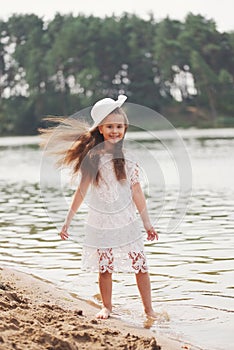 Cute happy little girl in sumer lake