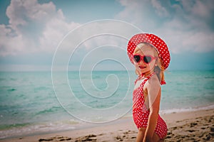 Cute happy little girl with sunglasses on beach vacation