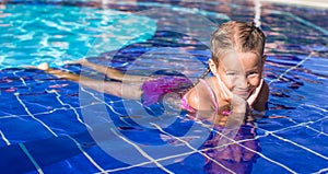 Cute happy little girl in the swimming pool