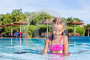 Cute happy little girl in the swimming pool
