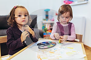 Cute happy little girls, preschooler, painting with water color