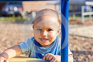 Cute happy smiling baby boy walking at children playground outdoors