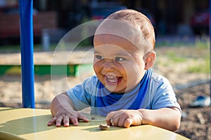 Cute happy smiling baby boy walking at children playground outdoors