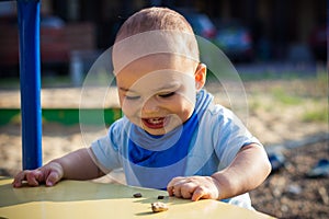 Cute happy smiling baby boy walking at children playground outdoors