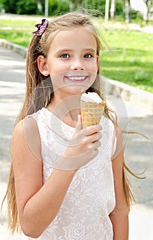 Cute happy smiling little girl child eating an ice cream outdoor