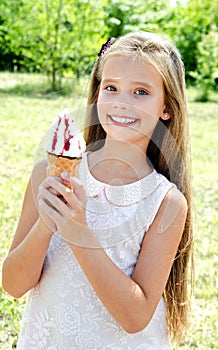 Cute happy smiling little girl child eating an ice cream outdoor