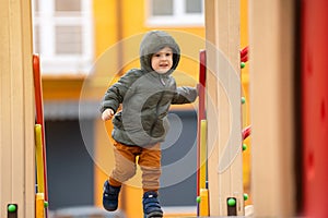 Cute happy toddler boy three years old is playing on the playground in a residential complex.