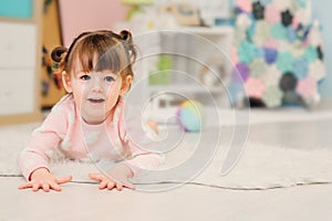 Cute happy 2 years old baby girl playing with toys at home