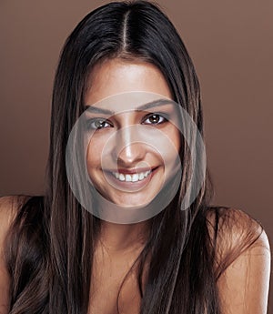 Cute happy young indian woman in studio close up smiling, fashion mulatto emotional posing, lifestyle people concept