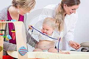 Cute and healthy baby girl playing with the stethoscope during routine check-up