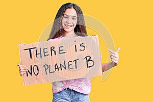 Cute hispanic child girl holding there is no planet b banner smiling happy pointing with hand and finger