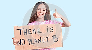 Cute hispanic child girl holding there is no planet b banner smiling happy and positive, thumb up doing excellent and approval