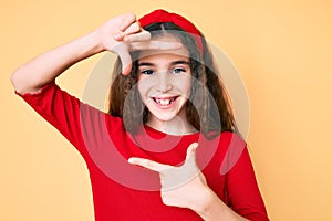 Cute hispanic child girl wearing casual clothes and diadem smiling making frame with hands and fingers with happy face