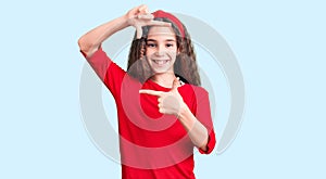 Cute hispanic child girl wearing casual clothes smiling making frame with hands and fingers with happy face