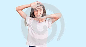 Cute hispanic child girl wearing casual white tshirt smiling cheerful playing peek a boo with hands showing face