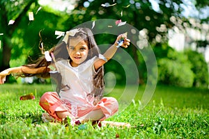 Cute hispanic girl throwing confetti