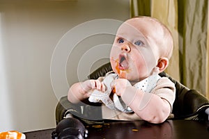 Cute hungry baby eating solid food