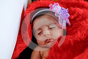 Cute Indian baby girl sleeping on bed