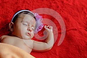Cute Indian baby girl sleeping on bed