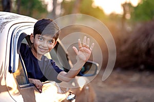 Cute Indian Child waving from car window