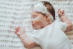 Cute infant child sleeping on white sheets