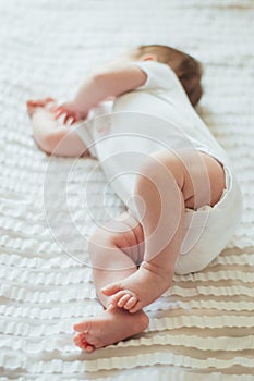 Cute infant child sleeping on white sheets