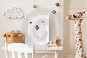 Cute interior of kid room with baby accessories, toys and poster frame.