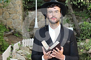 Cute Jewish man praying outdoors