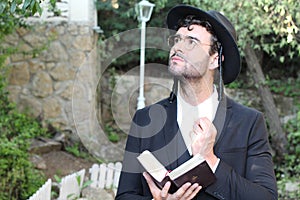 Cute Jewish man praying outdoors